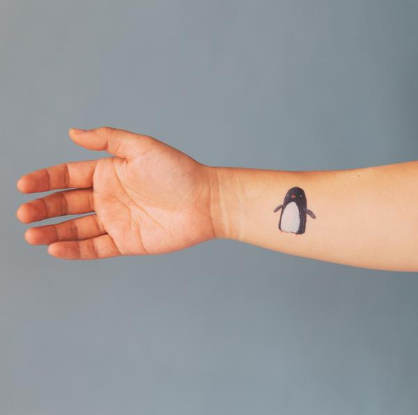 Hình xăm chim cánh cụt nhỏ bé nơi cổ tay