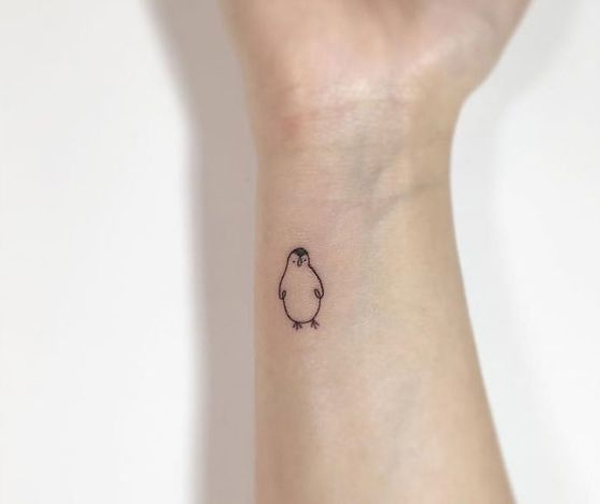 Hình xăm mini chim cánh cụt thiết kế tối giản trên cổ tay